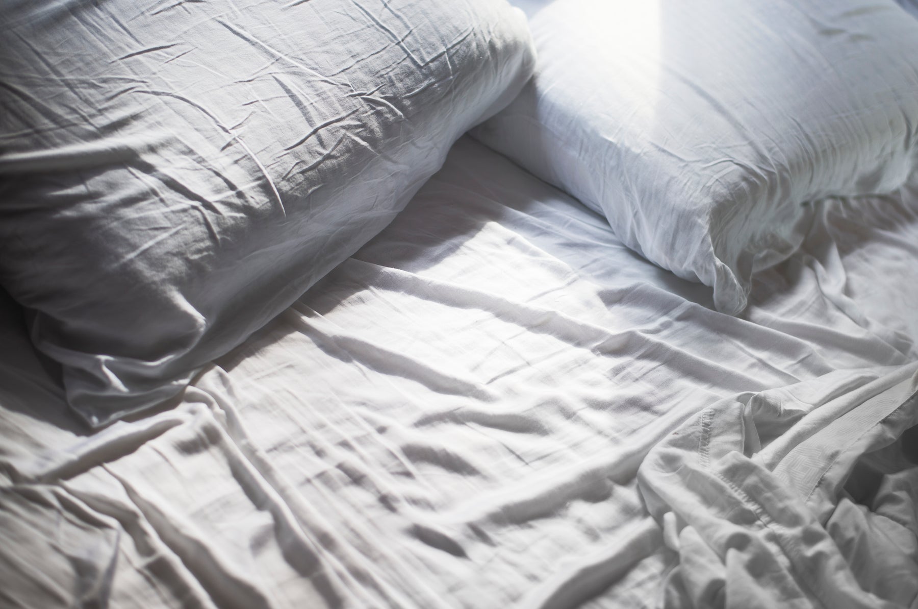 White pillows and sheets of a bed unmade